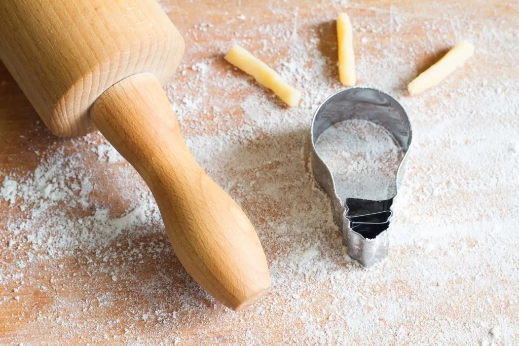 Rolling pin with lightbulb cookie cutter on dough